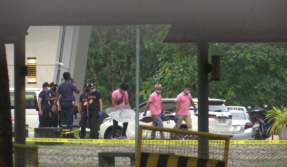 Police investigators carry the body